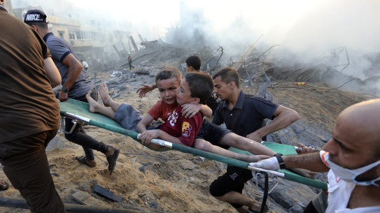 Palestinians evacuate two wounded boys out of the destruction following Israeli airstrikes on Gaza City, Wednesday, Oct. 25, 2023. The U.N. warned on Wednesday that it is on the verge of running out of fuel in the Gaza Strip, forcing it to sharply curtail relief efforts in the territory blockaded and devastated by Israeli airstrikes since Hamas militants launched an attack on Israel more than two weeks ago.(AP Photo/Abed Khaled)