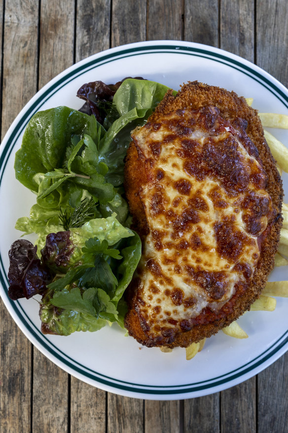 Chicken Parmi, ham,napoli sauce, cheese, chips and local leaves.  