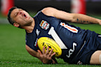 Brendan Fevola reacts after hurting his leg.