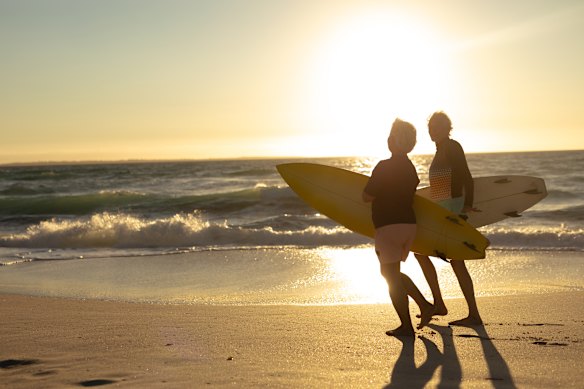 Retired couple surfing at sunset