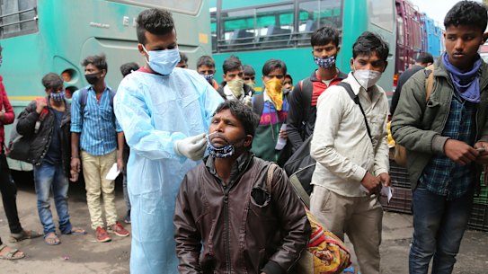 A health worker tests a man for COVID-19 at a bus station in Jammu, India.