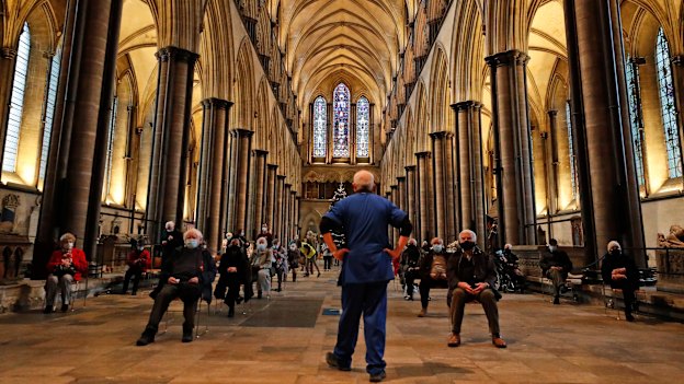 A medic monitors people who sit and wait after receiving their vaccine at Salisbury Cathedral. 