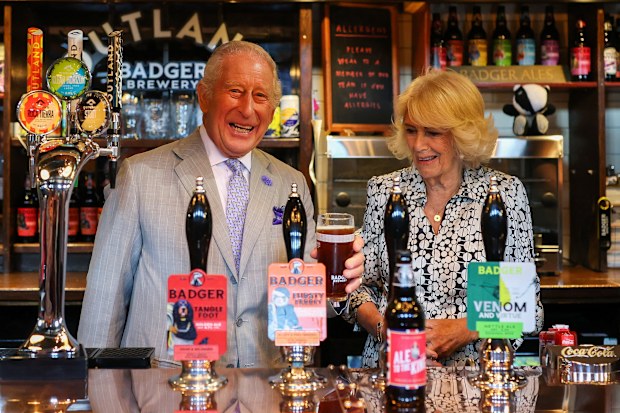 King Charles III holds a pint next to Queen Camilla in the Hall and Woodhouse Badger Brewery bar as the brewery celebrates its 250th anniversary in Blandford Forum, south England, Thursday July 16, 2026