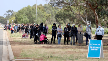 Long queues form outside a testing site at Parafield Airport in Adelaide's northern suburbs on Monday.