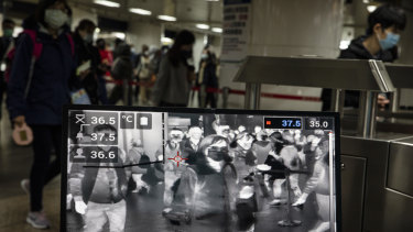 Taipei metro staff monitor the temperatures of passengers with a thermal scanner on Friday. Singapore and Hong Kong have had more successful approaches in battling the pandemic given their experience with SARS in 2003. 