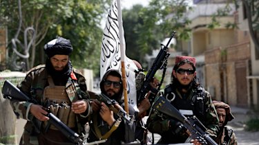 Taliban fighters display their flag on patrol in Kabul, Afghanistan. 