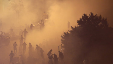 Lebanese riot police fire tear gas during a protest against government's plans to impose new taxes in Beirut, Lebanon.