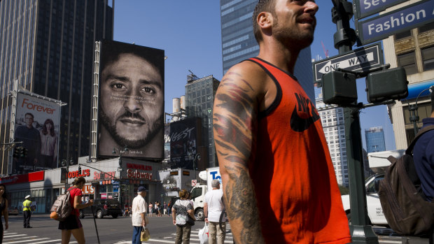 People walk by a Nike advertisement featuring Colin Kaepernick in New York. 