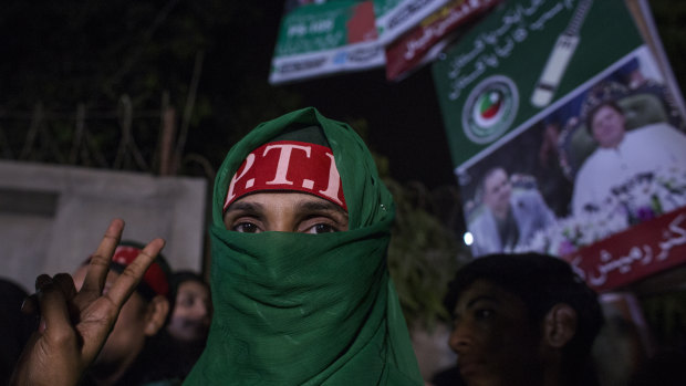 Supporters of Imran Khan, head of the Pakistan Tehreek-e-Insaf (PTI), also known as Movement for Justice, celebrate on a street in Karachi.