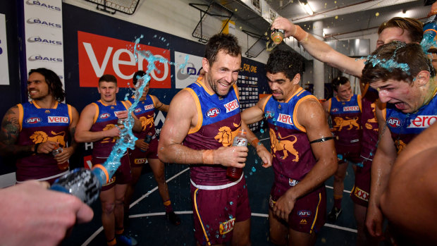 Winning grins: Luke Hodge and Charlie Cameron get under the Gatorade shower after the Lions break-through win.