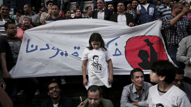 A 2016 protest to mark World Press Freedom Day in Cairo, where a girl stands in front of a banner reading "Remove our shackles". 