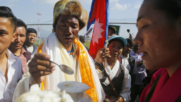 Rita eats yoghurt to celebrate his return from the Everest summit.