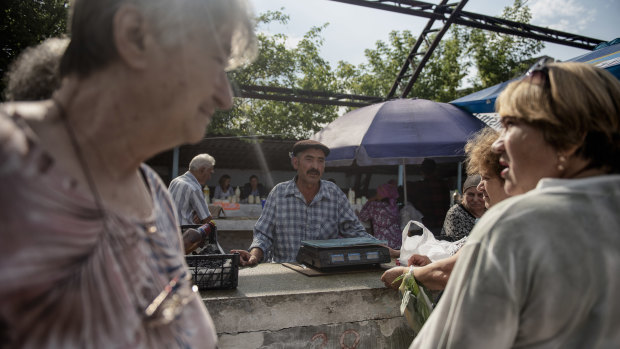 Grisa Muntean, centre, at the market town of Telenesti, 35 kilometres from his home.