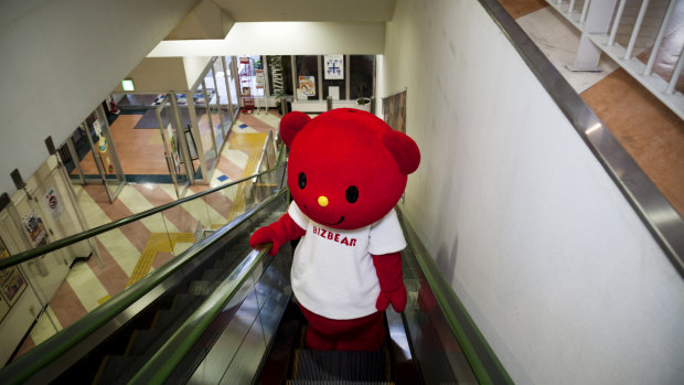 Bizbear, a mascot, rides the escalator at the factory of Kigurumi.biz, a mascot-maker based in Miyazaki, Japan in 2015.