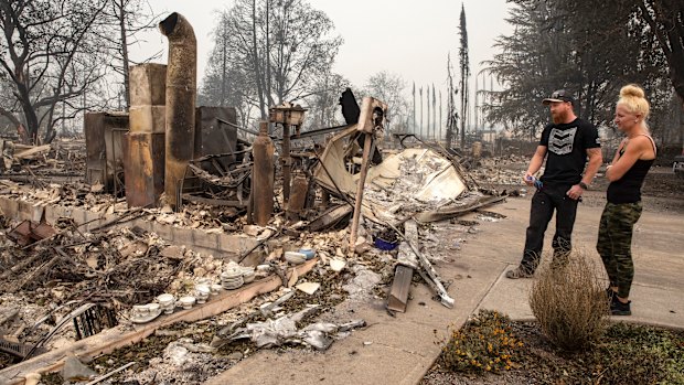 Derek Trenton and Shawna Haptonstall  look at the ruins of Derek's parents home in Talent, Oregon as wildfires devastate the region.