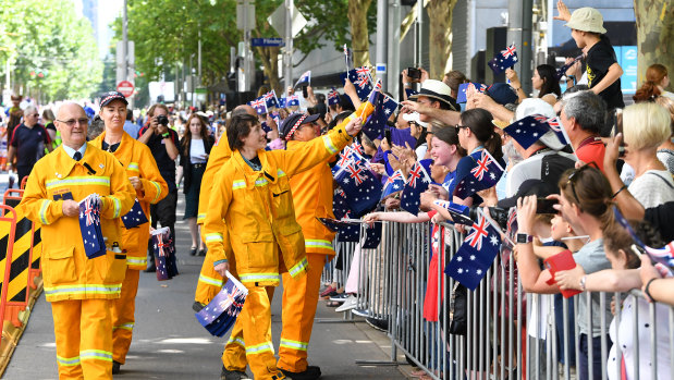 CFA volunteers are greeted by the crowd watching the parade.