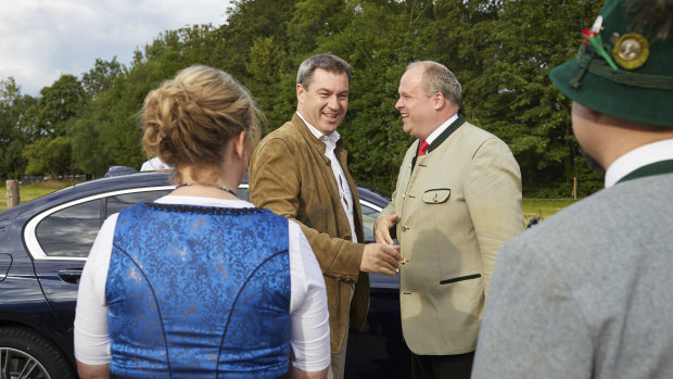 Markus Söder, second from left, the premier of Bavaria, arrives at a festival in Baierbrunn, near Munich, in June.