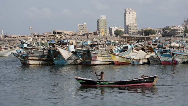 A fisherman paddles his boat past destroyed buildings on the coast of the port city of Hodeida, Yemen. 