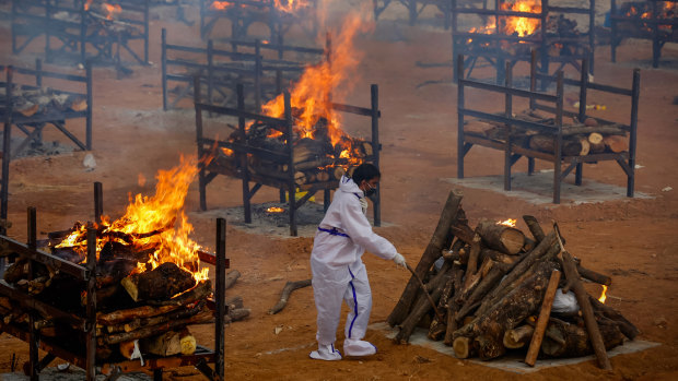 A man performs the last rites for a COVID-19 victim at a temporary crematorium in Bengaluru, India.