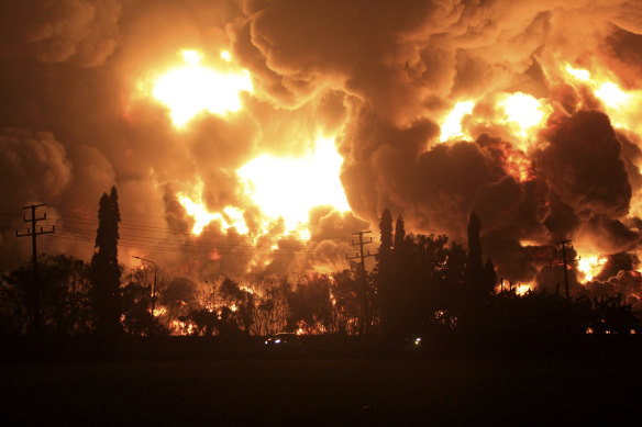 Cars pass by as fire razes through Pertamina Balongan Refinery in Indramayu, West Java, Indonesia, early on Monday, March 29.