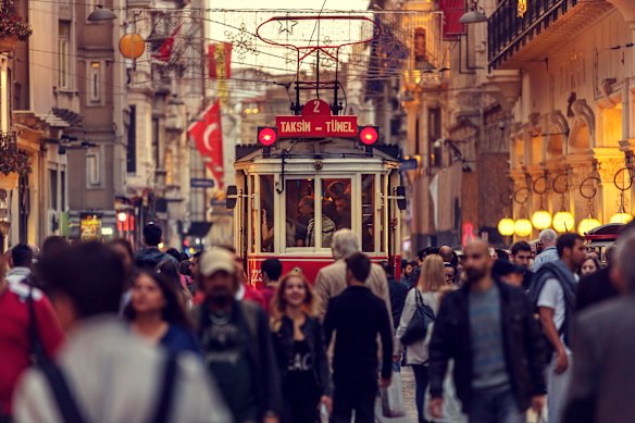 A tram passes along crowded Istiklal Street in Istanbul, Turkey.