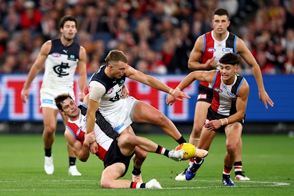 Patrick Cripps of the Blues kicks whilst being tackled by Jack Steele of the Saints.