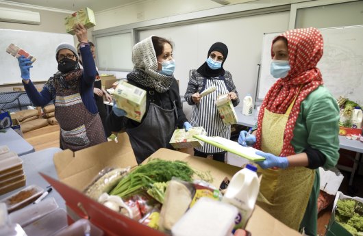 Afshan Mantoo (centre) and her group of volunteers preparing food at their kitchen in Coburg.