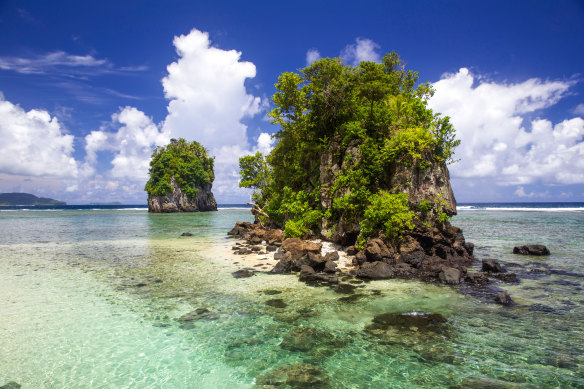 Scenic tree-topped rocky outcrops rise from the lagoons of American Samoa.