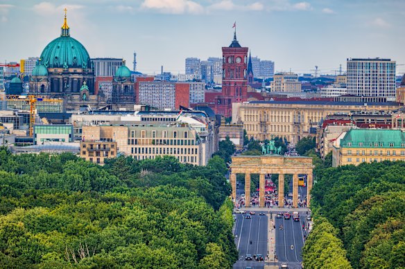 The Berlin city skyline with views over Tiergarten park to the Brandenburg Gate, cathedral and the so-called “red city hall”. 