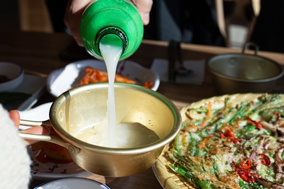 Some food on the side (here a seafood pancake) with some makgeolli pouring.