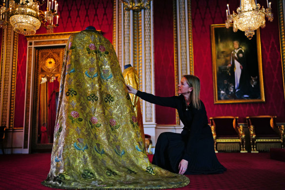 Caroline de Guitaut, deputy surveyor of the King’s Works of Art for the Royal Collection Trust, adjusts the Imperial Mantle.