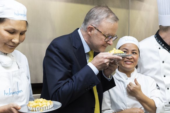 Opposition Leader Anthony Albanese smells an apple tart that was just made, during a visit to a commercial cooking class at the Holmesglen Institute in the seat of Chisholm, in Melbourne, Victoria.