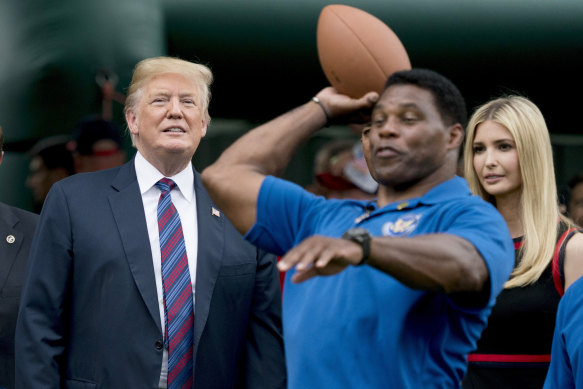 Donald Trump ve kızı Ivanka, eski NFL oyuncusu Herschel Walker'ın 2018'deki bir Beyaz Saray etkinliği sırasında futbol atışını izliyor. Herschel, ara sınavlarda kaybeden Trump destekli uzun bir aday grubuna katılıyor.