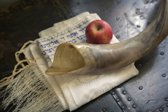 A ram’s horn, or shofar; a Jewish prayer shawl, or talit; and an apple symbolise Rosh Hashanah.