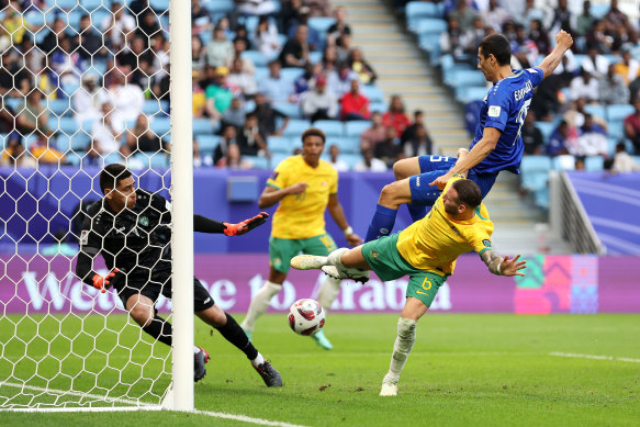 Martin Boyle shoots whilst under pressure from Umar Eshmurodov of Uzbekistan.