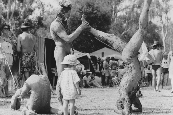 Mud-covered men do yoga at Down to Earth Confest in Wangaratta in 1984.
