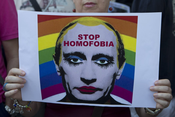 A woman holds a poster depicting Russian President Vladimir Putin during a protest in front of the Russian embassy in Madrid, Spain in 2013.