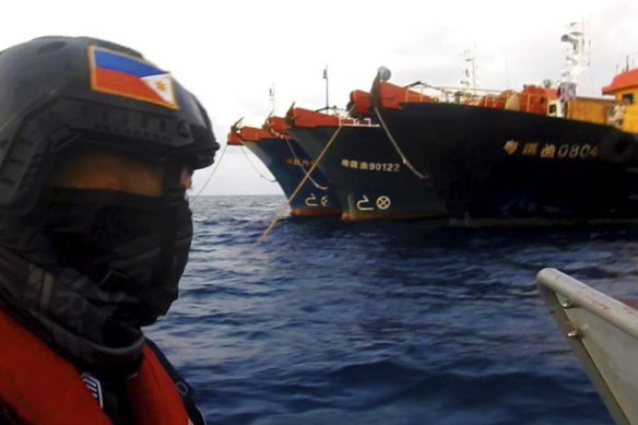 Members of the Philippine Coast Guard patrol beside Chinese vessels moored at Whitsun Reef, South China Sea, in April.