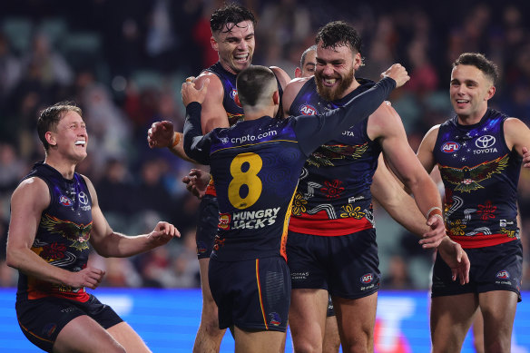 Riley Thilthorpe of the Crows celebrates a goal with teammates.