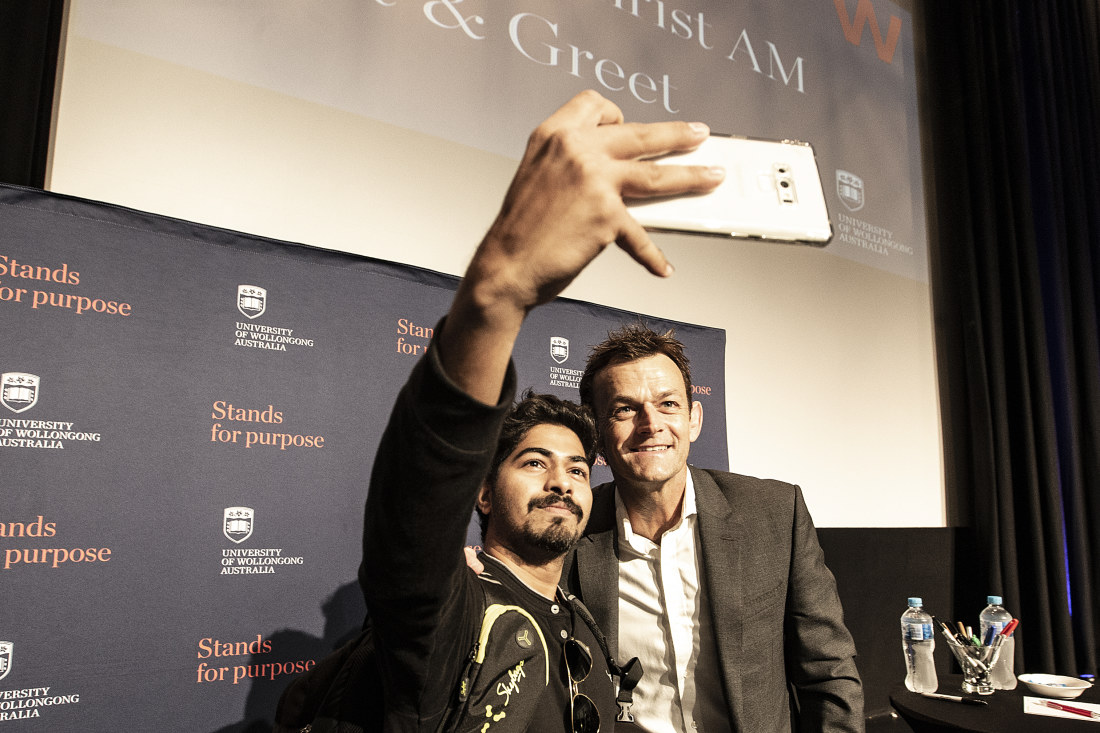 A university student takes a selfie with retired cricketer Adam Gilchrist.