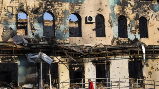 A woman walks by a destroyed building in Izium, Ukraine.