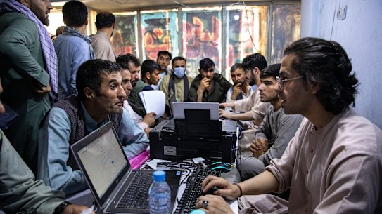Afghans crowd into the Herat Kabul internet cafe to apply for visas. 