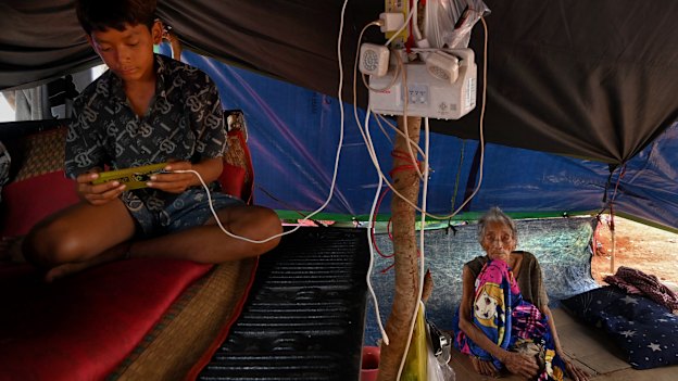 Touch Makara, 15, with his 98-year-old great-great-grandmother, Ron Touch, in their shelter at the Wat Bat Th’Kao camp. 