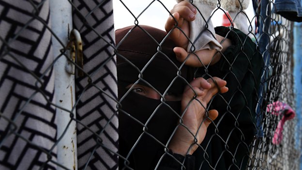An Islamic State woman at the fence line of the foreign section of al-Hawl camp in Syria.