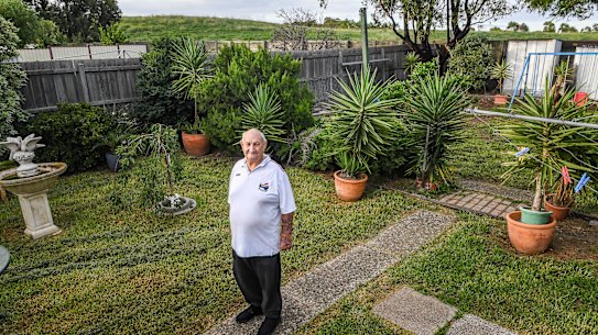 Bill Cartledge in his back yard with the hill which was built on top of the Sunshine Landfills tip in the background.