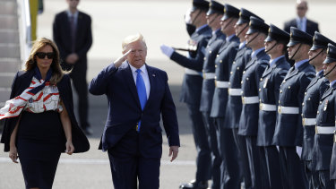 President Donald Trump salutes an honour guard as he and first lady Melania Trump arrive at Stansted Airport in England.