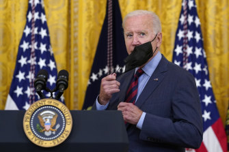Joe Biden removes his mask at an event in the East Room of the White House