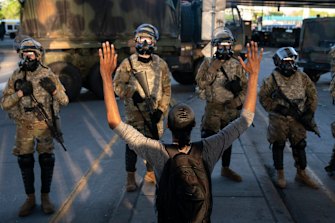 A protester with hands up in front of the National Guard line moments before the curfew was scheduled to begin in Minneapolis.