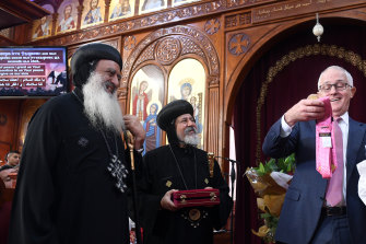 Then prime minister Malcolm Turnbull, right, inspects a Donald Trump tie given to him by Coptic Orthodox Bishop Daniel, centre, while Grace Bishop Paula, Diocese of Tanta in Egypt, looks on in 2017.