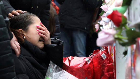 Vicente Juarez's daughter Diana cries at a memorial for him in Aurora, Illinois.  He was shot by a man whose out-of-state conviction wasn't picked up before he was sold a gun. 